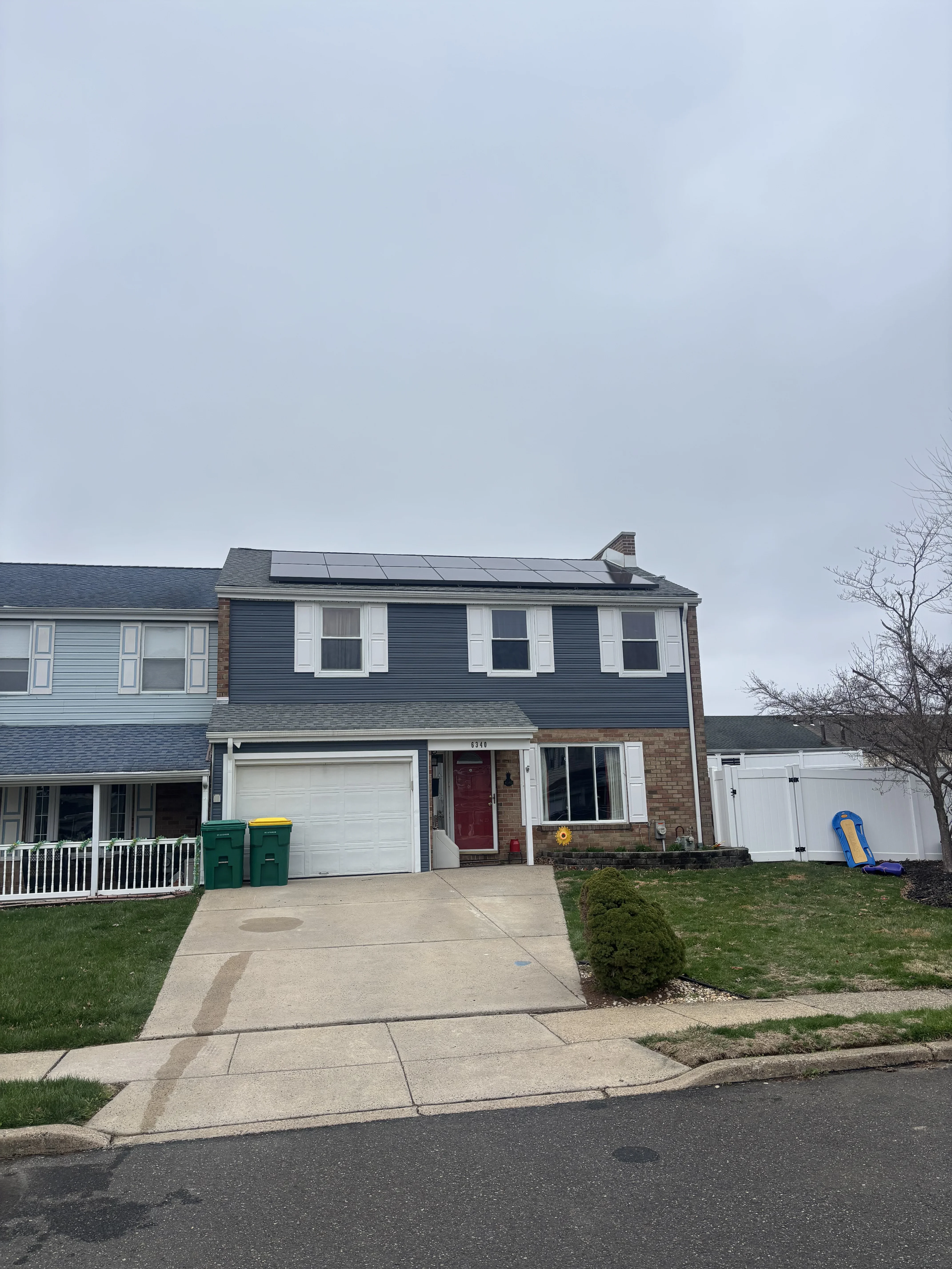 Solar panels installed on residential roof with gray shingles and white trim
